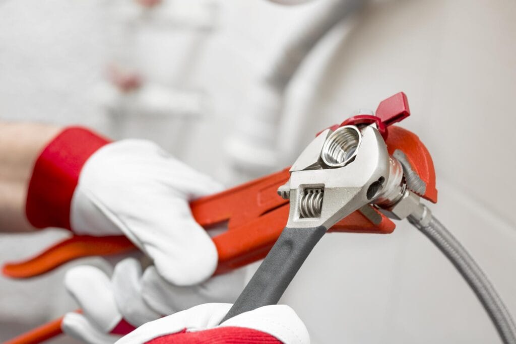 Plumber holding pipe wrenches for an emergency repair in Melbourne