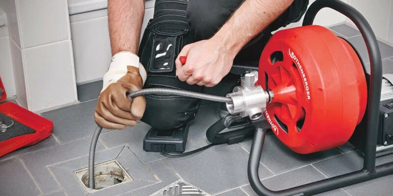 Plumber using a drain-cleaning machine in Melbourne