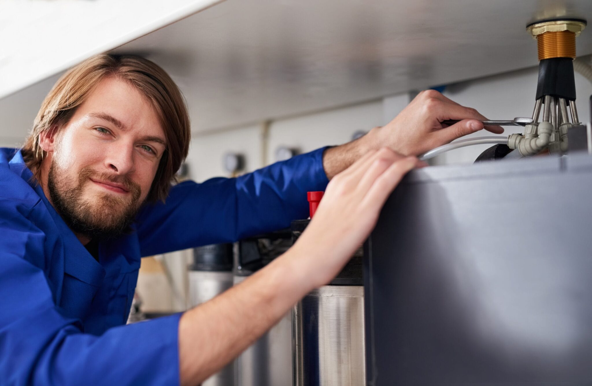 Technician servicing a residential water heater tank in Melbourne